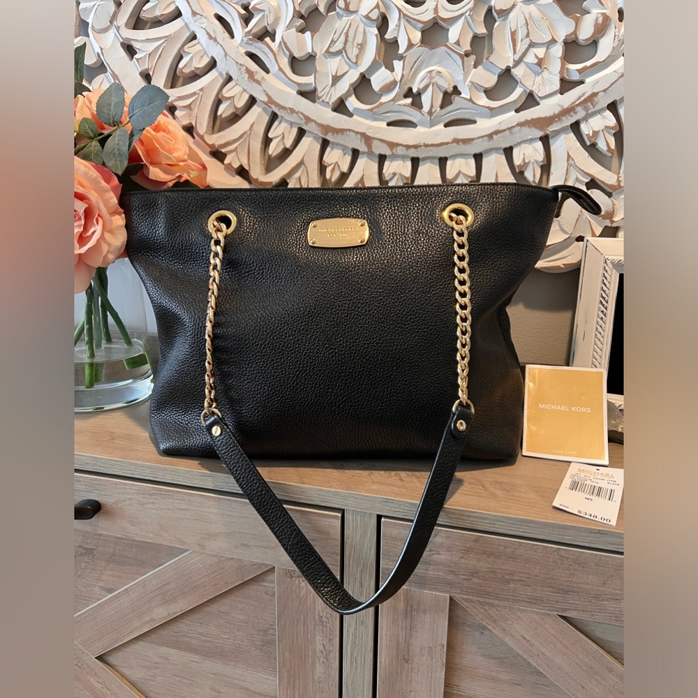Michael Kors black pebbled leather tote with gold accents.